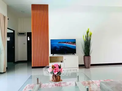 Modern living room with stylish decor and large TV, perfect for relaxation and entertainment.