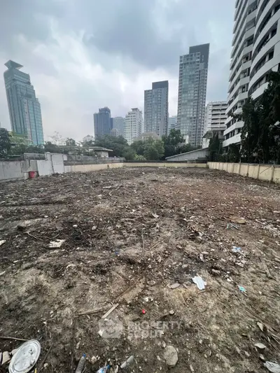 Vacant urban land plot with city skyline backdrop, ideal for development opportunities.