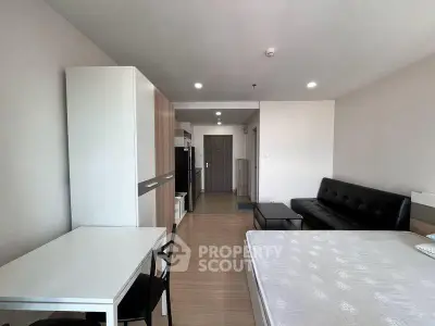 Modern studio apartment with open layout, featuring a sleek kitchen and cozy living area.