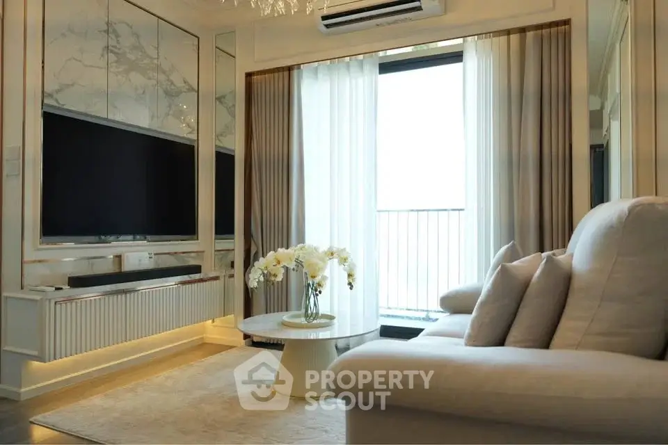 Luxurious living room with elegant decor and large TV, featuring a cozy sofa and stylish coffee table.