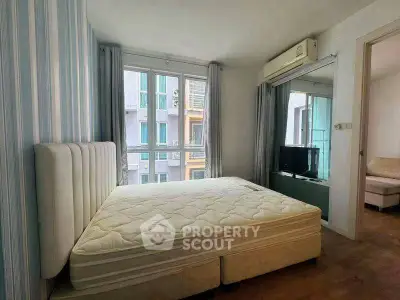 Cozy bedroom with large window and air conditioning in modern apartment