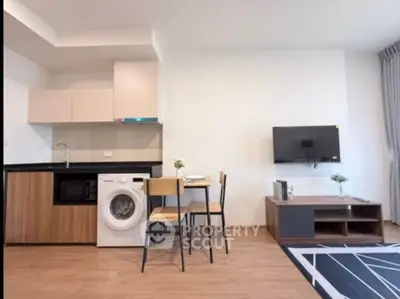Modern open-layout kitchen with washing machine and cozy dining area in stylish apartment.