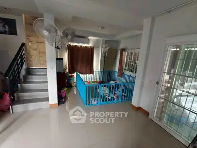 Spacious living room with playpen and modern staircase