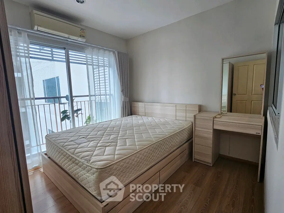 Modern bedroom with balcony access and natural light in a stylish apartment.