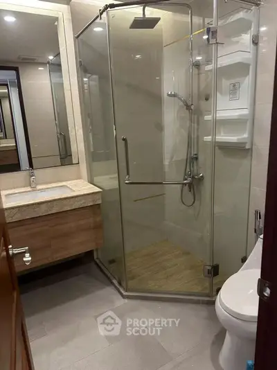 Modern bathroom with glass shower enclosure and sleek vanity in a contemporary home.