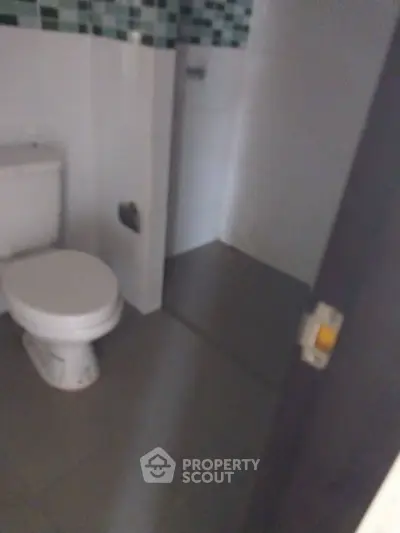 Compact bathroom with modern tiles and white fixtures, ideal for efficient space utilization.