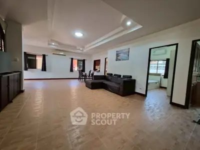 Spacious open-plan living room with modern furnishings and ample natural light.
