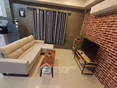 Modern living room with stylish brick wall, cozy sofa, and sleek TV setup.