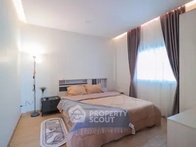 Cozy bedroom with natural light and modern decor, perfect for relaxation.