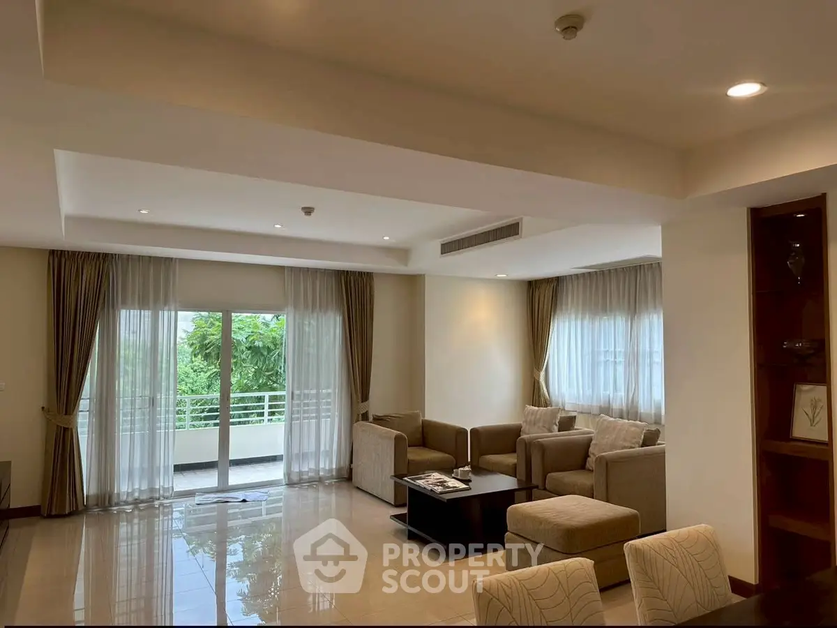 Spacious living room with elegant furniture and large windows offering natural light.