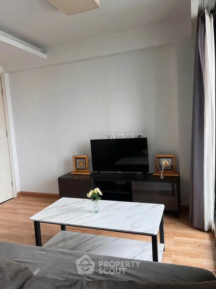 Modern living room with sleek TV stand and marble coffee table, perfect for cozy relaxation.