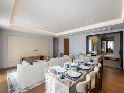 Luxurious open-plan living and dining area with elegant decor and modern lighting.