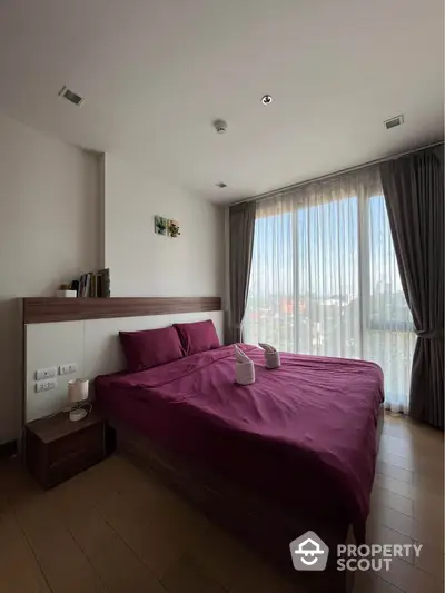 Modern bedroom with large window and elegant decor in a stylish apartment.