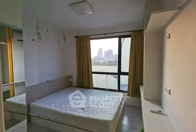 Spacious bedroom with city view and natural light, featuring a comfortable bed and modern decor.