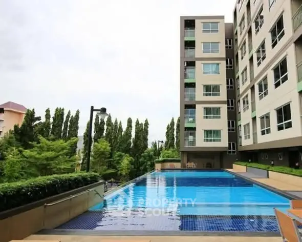 Modern apartment building with a stunning outdoor pool and lush greenery.