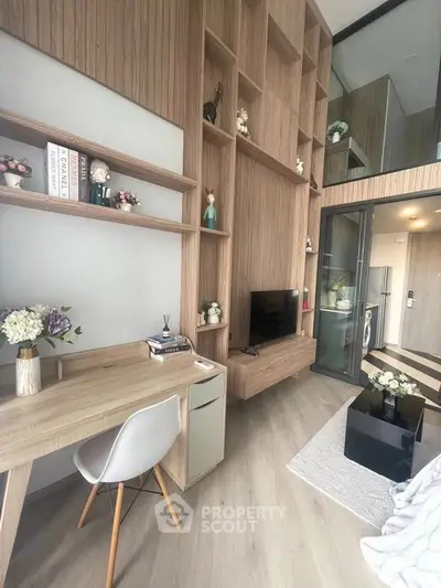 Modern living room with high ceilings, stylish shelving, and cozy workspace in a chic apartment.