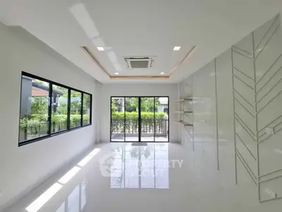 Bright and spacious living room with large windows and modern ceiling design.