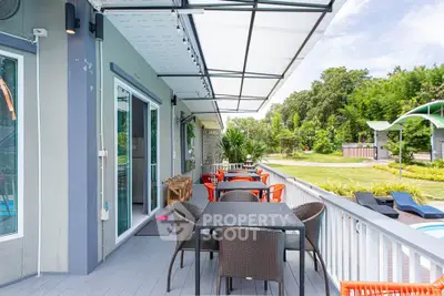 Spacious balcony with outdoor dining set and lush garden view, perfect for relaxation and entertainment.