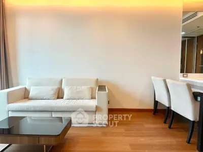 Modern living room with elegant furniture and warm lighting, featuring a cozy sofa and stylish dining area.