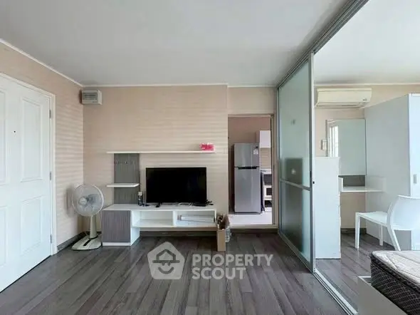 Modern living room with sleek flooring and stylish furniture, featuring a TV and open layout.