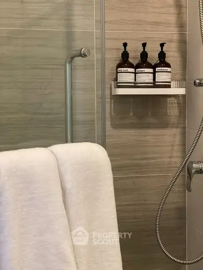 Modern bathroom with sleek shower and elegant toiletries, perfect for a luxurious living experience.