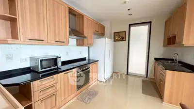 Modern kitchen with wooden cabinets, sleek appliances, and a spacious layout.