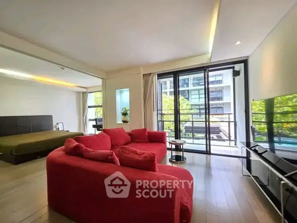 Spacious modern living room with red sofa and balcony view in luxury apartment