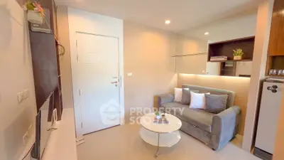 Cozy modern living room with stylish decor and comfortable seating in a compact apartment.