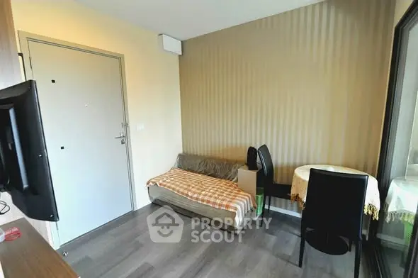Cozy small living area with sofa bed and dining table in modern apartment.