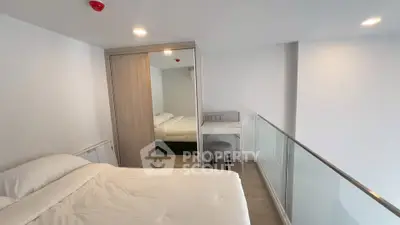 Modern bedroom with minimalist design and glass railing, featuring a cozy bed and built-in wardrobe.