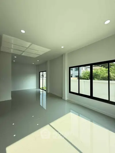 Spacious modern living room with large windows and glossy tile flooring