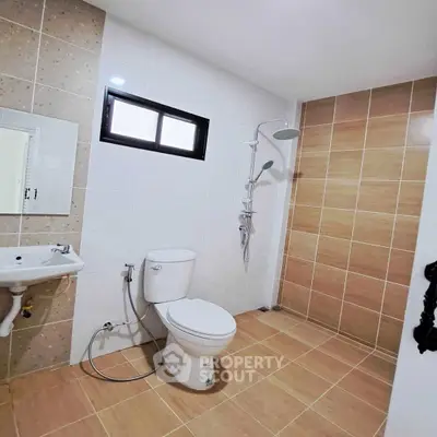 Modern bathroom with shower and toilet in a tiled interior