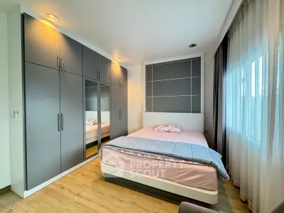 Modern bedroom with sleek built-in wardrobe and cozy bed, featuring soft lighting and elegant curtains.