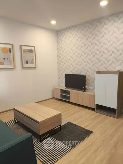 Modern living room with stylish decor, featuring a sleek TV stand, contemporary artwork, and elegant lighting.