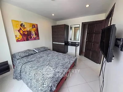 Spacious bedroom with modern decor and wall art, featuring a comfortable bed and sleek furniture.