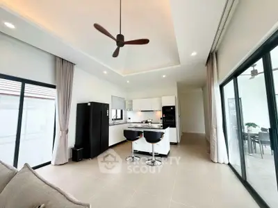 Modern open-layout kitchen with sleek design and island seating in a bright, spacious living area.