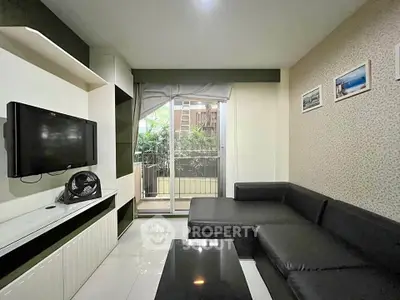 Modern living room with sleek black sofa and balcony view