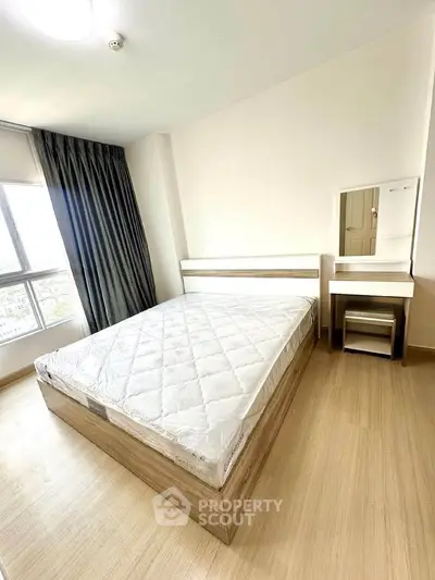 Bright bedroom with large window and modern furnishings in a stylish apartment.