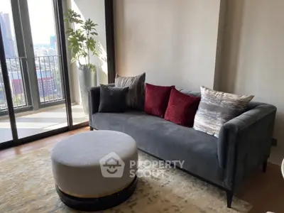 Stylish living room with modern sofa, plush cushions, and balcony view.