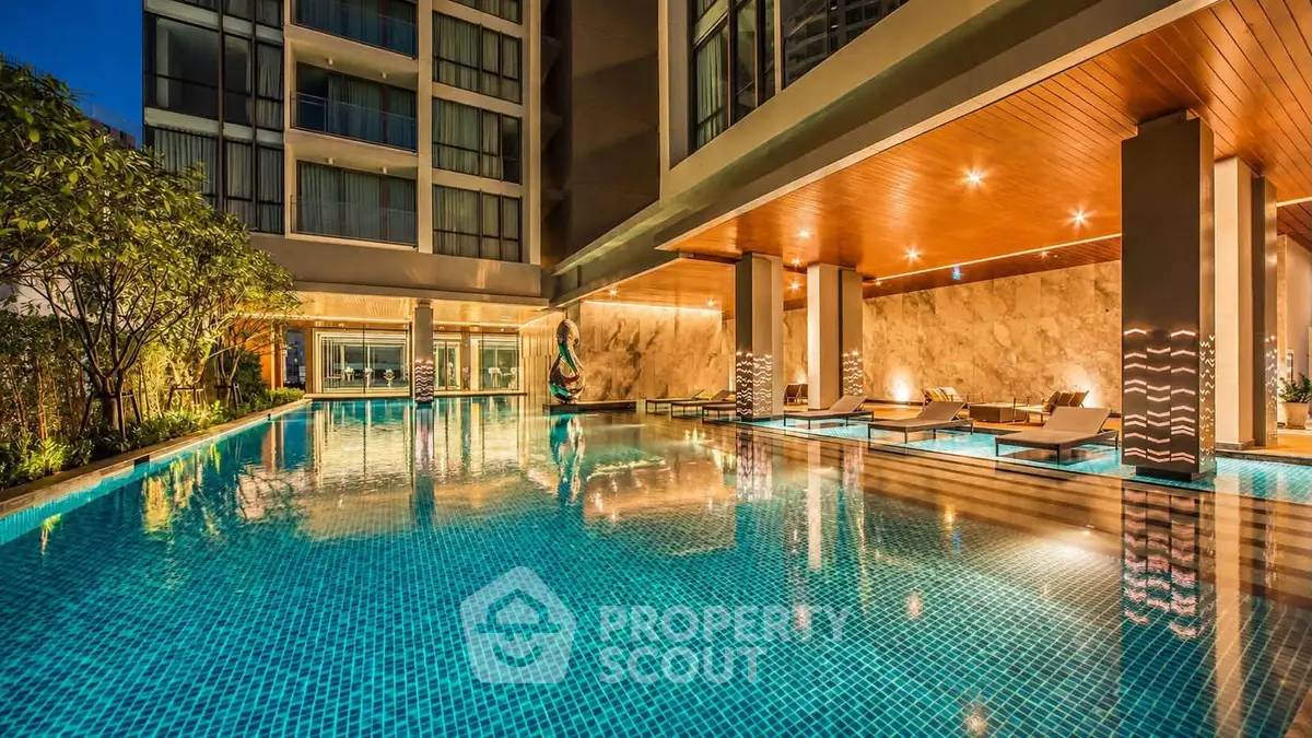 Luxurious apartment complex with stunning illuminated pool and modern architecture.