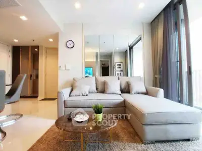 Modern living room with stylish sofa and glass wall in a bright apartment