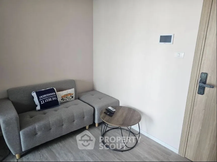 Cozy living room with modern gray sofa and stylish round coffee table.