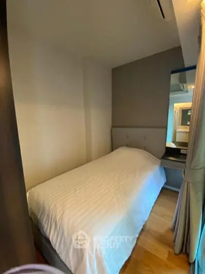 Cozy bedroom with single bed and modern decor in a stylish apartment.