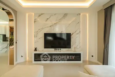 Luxurious living room with marble accent wall and modern TV setup