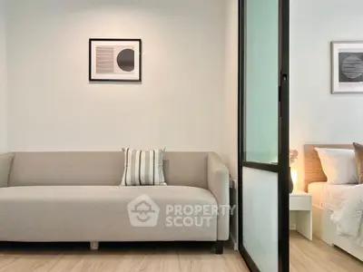 Modern living room with stylish sofa and adjacent bedroom view.