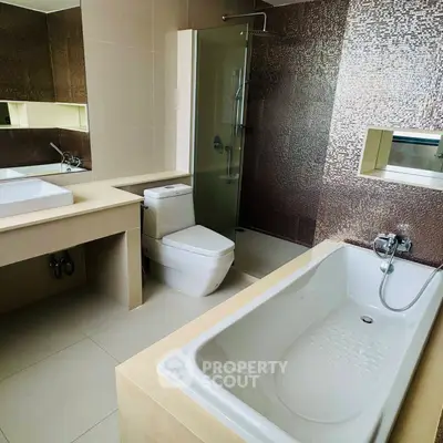 Modern bathroom with bathtub, shower, and sleek fixtures in a contemporary design.