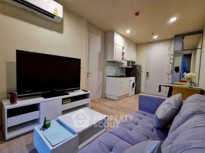 Modern living room with sleek furniture and integrated kitchen appliances.
