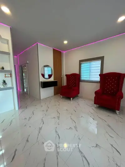 Modern living room with elegant red chairs and marble flooring, featuring ambient LED lighting.
