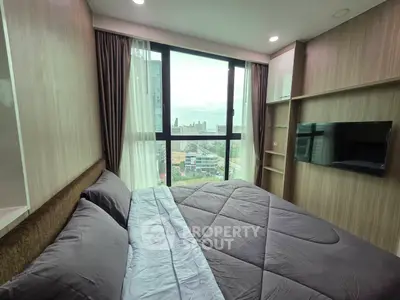 Modern bedroom with large window offering city view, featuring sleek design and cozy bedding.