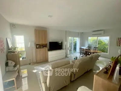 Spacious living room with modern decor and large windows offering garden views.